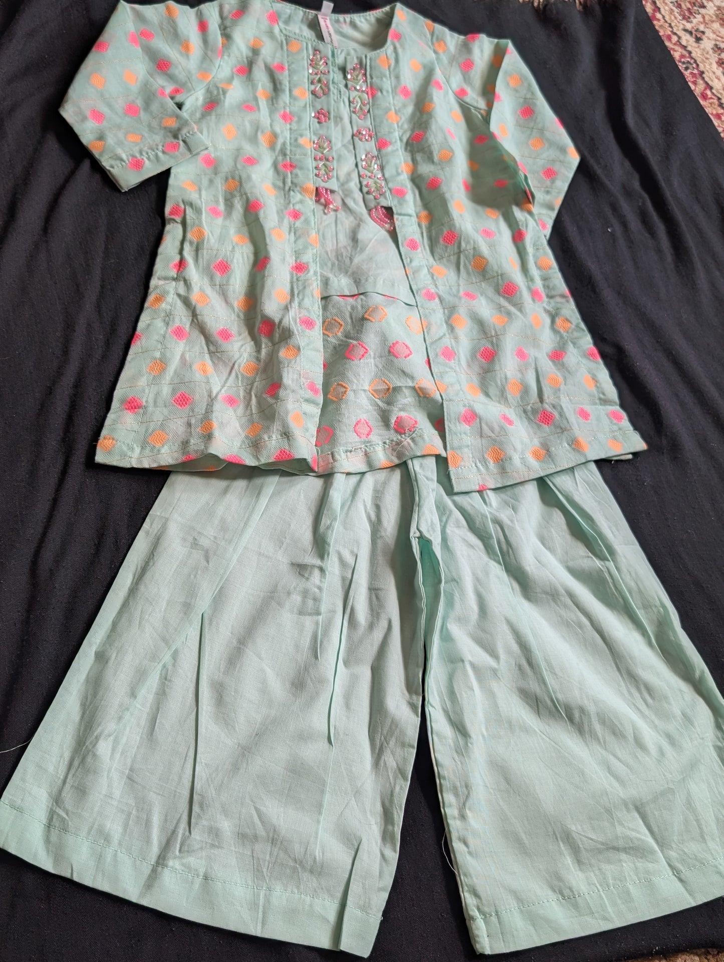 Girls mint green ethnic outfit featuring a diamond-patterned embroidered top with embellishments along the placket, paired with matching wide-leg trousers.