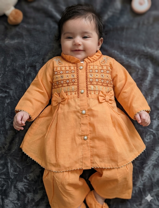 Infant  peach-orange peplum outfit  a high neckline, crystal buttons,  geometric embroidery, and matching flounced garara pants.
