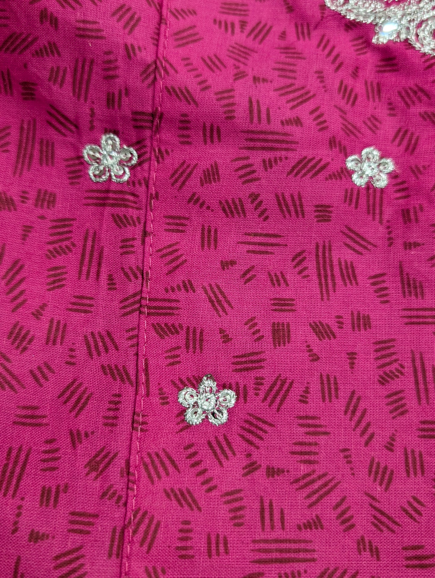 A girls' pink cotton kurta featuring a self-print and embroidery, paired with matching pants and a net dupatta.