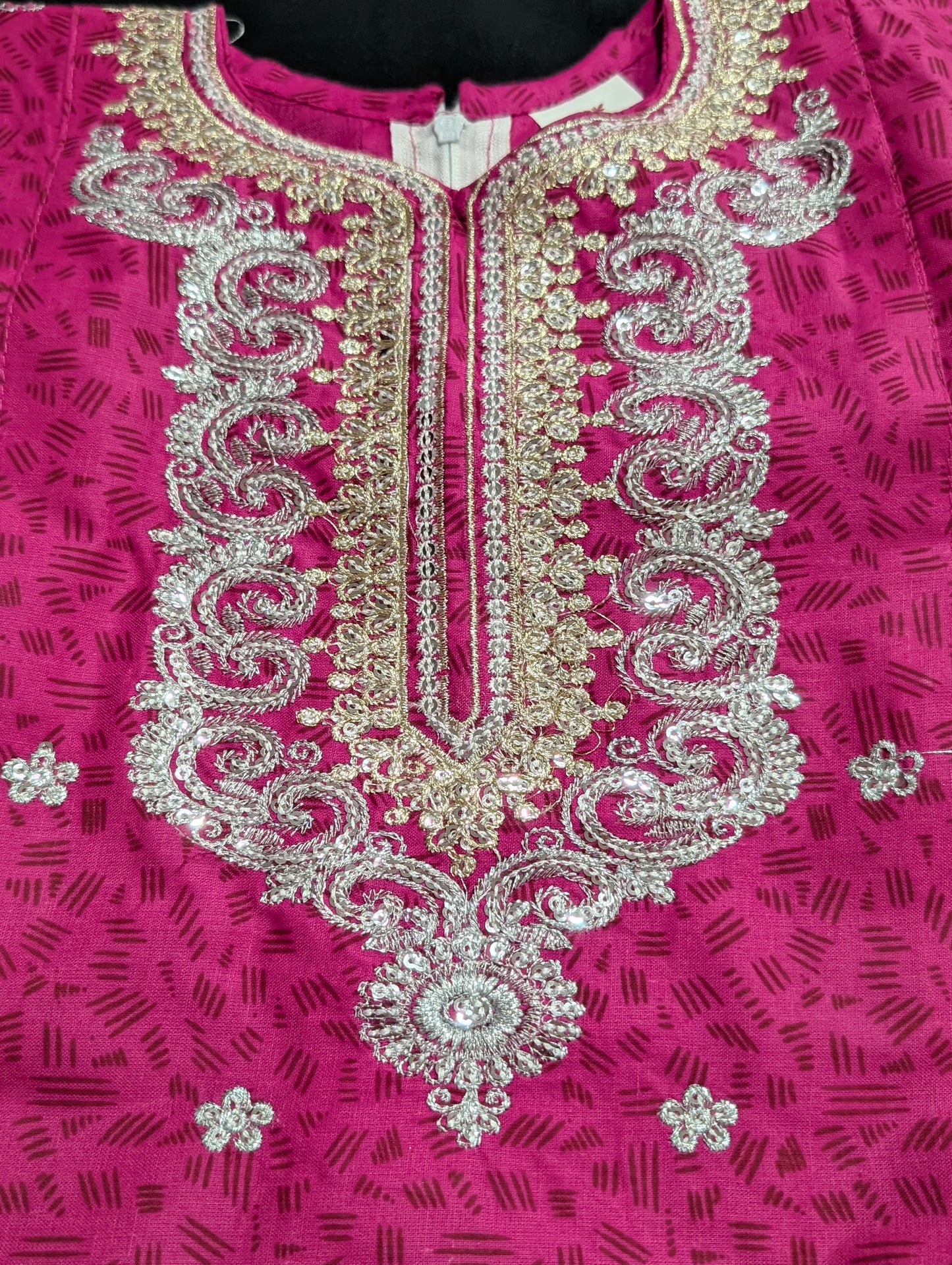 A girls' pink cotton kurta featuring a self-print and embroidery, paired with matching pants and a net dupatta.