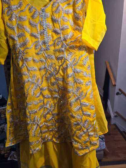 Girl's vibrant yellow traditional ethnic outfit featuring frock intricate gold embroidery across the tunic and matching bottoms gharara.