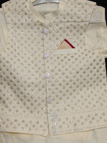 An off-white kurta, matching pants, and a gold embroidered waistcoat.